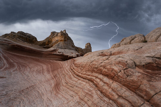 Dramatic lightning over vermillion desert landscape