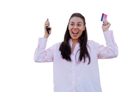 Joyful female shopper celebrating digital purchase, gripping smartphone and credit card, displaying excitement against clean white background