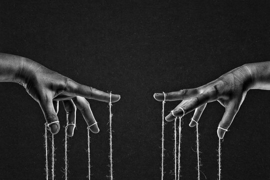 Hands with Controlling Strings, Manipulation Concept in Black and White on Textured Paper Background
