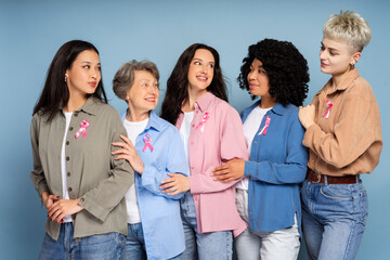 Obraz premium Women of different ages and ethnicities wearing pink ribbons are embracing each other