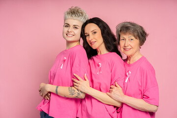 Smiling women of different ages wearing pink supporting breast cancer awareness