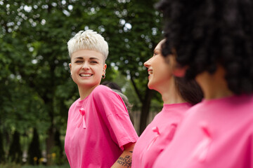 Group of smiling women wearing pink supporting breast cancer awareness