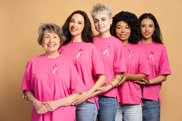Diverse group of smiling women embracing and supporting breast cancer awareness