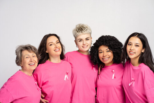 Group of smiling women wearing pink t shirts supporting breast cancer awareness - Powered by Adobe