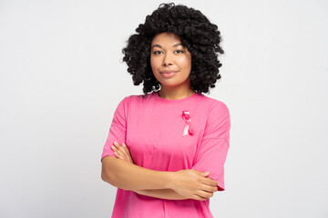 Confident young African American woman wearing pink ribbon supporting breast cancer awareness