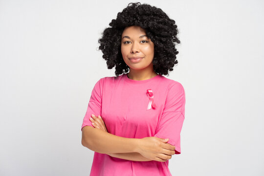Confident young African American woman wearing pink ribbon supporting breast cancer awareness