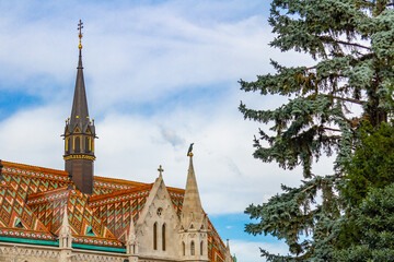 Close-up of Matthias Cathedral roof fragment with colorful diamond-pattern tiles and raven...
