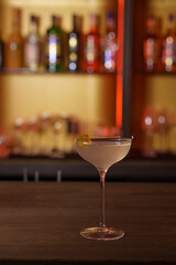 Cocktail in a tall glass against the background of a dark bar