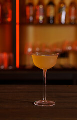 Cocktail in a tall glass against the background of a dark bar