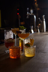 Cocktails in tall glasses on a bar counter in a dark bar