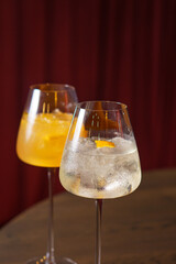 Orange cocktail in a glass goblet in a dark bar
