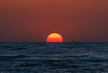 Beautiful landscape with sunrise over the sea. The sun rises from the sea water