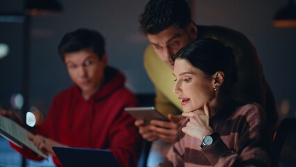 Professional teammates brainstorming on startup checking data on tablet closeup.