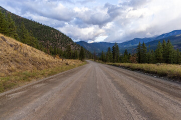 Fototapeta premium Scenic Dirt Road in a Forested Valley with Mountain Views