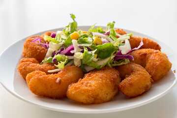 Piatto con gamberi impanati fritti e insalata mista