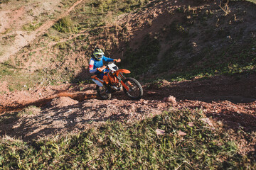 Motocross rider driving on dirt track in nature