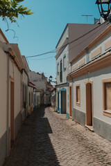 Narrow cobblestone street with traditional Portuguese houses in Algarve