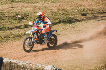 Motocross rider racing on dirt track leaving dust trail