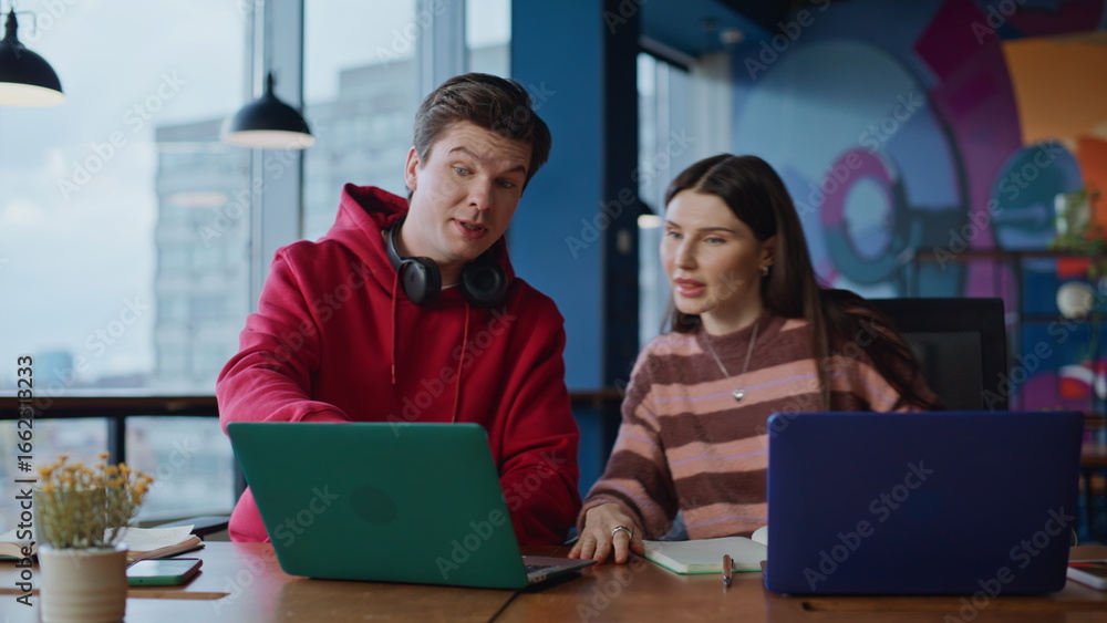 Poster man employee asking colleague to help with online program in coworking closeup.