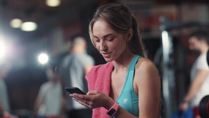 Smile girl makes a break in the gym listening music use phone sport fitness work-out exercise healthy body active muscle indoors sportswear strong strength portrait close up attractive - Powered by Adobe