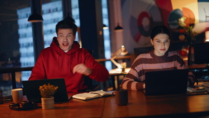 Emotional team rejoicing achievement at dark office coworking space closeup. 