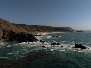 Fototapeta premium Aerial view of rocky shoreline and waves along Algarve coast, Portugal