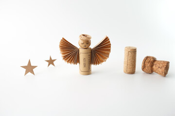 Eco-friendly angel figurine made from wine cork and folded paper, displayed on white surface....