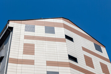 Modern building facade with geometric pattern and blue sky
