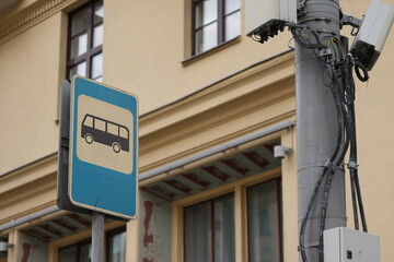 Obraz premium Close-up of a blue bus stop sign on a city street with building in the background 
