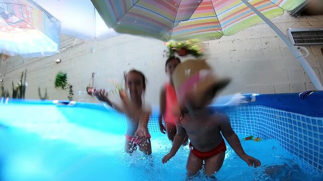 Happy children playing in a backyard swimming pool