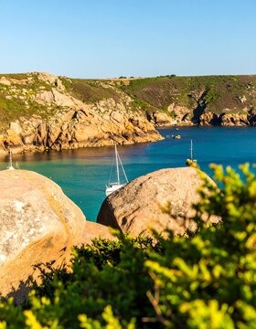 Coastal scene, rocks, and sailboat