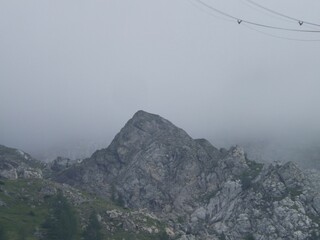 A long exposure shot of high-voltage power lines gracefully suspended above a rugged mountain peak...