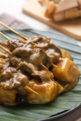 Sate padang. Padang satay made from beef with peanut curry sauce. served with lontong or rice cake. perfect for recipe, article, or any commercial purposes.