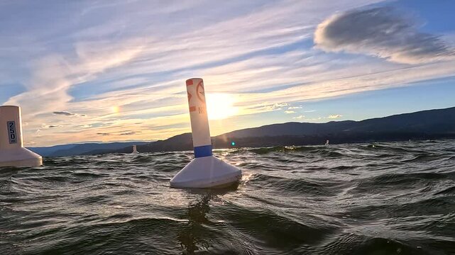 Two marker buoys floating with the waves in Lake Okanagan at sunset
