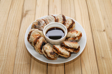 Pempek tunu. indonesian grilled fish cake served with cuko or sour and spicy dip sauce.