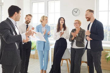 A group of six professionals gathers in a bright office to celebrate a recent achievement, exchanging smiles and applause, showcasing teamwork and positivity in their work environment.