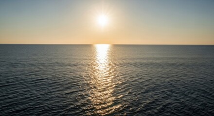 Obraz premium Tranquil seascape at dawn featuring golden sunbeams reflecting on water surface