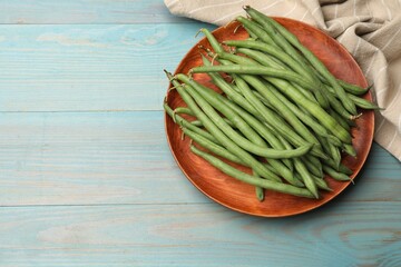 Many raw green beans on blue wooden table, top view. Space for text