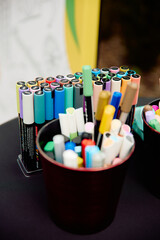 Colorful markers arranged on black table
