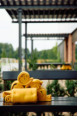 Stack of yellow towels on outdoor bench
