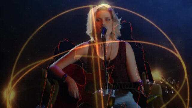 Singer entering spotlight strumming guitar, singing arcs swirling around her engaging audience