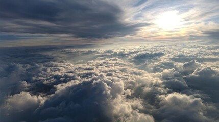 Naklejka premium Aerial perspective of sunlit clouds below a dramatic sky, showing various cloud formations