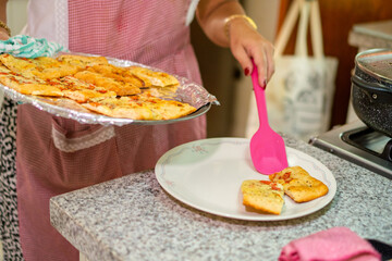 Woman serving freshly baked garlic bread for lunch