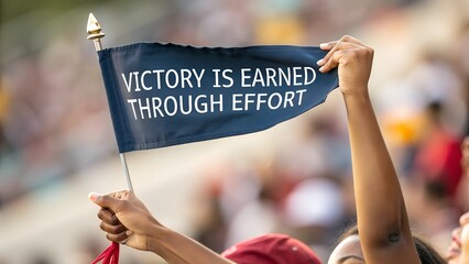 Hands Holding Flag with Message about Victory and Effort at Event