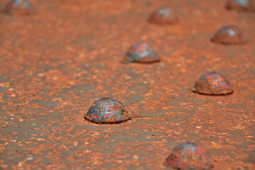 Rusted rivet on steel structure. Rust damage on steel bridge. Heavy duty fasteners on industrial...