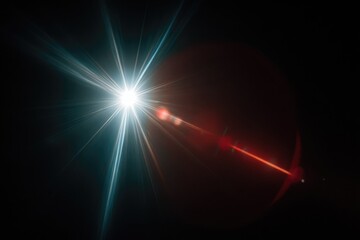 Bright starburst with teal and red lens flare against black