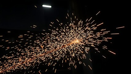 Industrial workshop scene with glowing sparks captured in motion against a dark backdrop.
