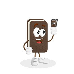 A cartoon chocolate ice cream sandwich character taking a selfie with a smartphone. It has a happy expression and is holding the phone in front of itself