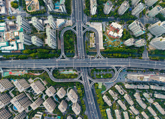 Aerial top down view of a busy junction reveals a multitude of vehicles traveling on various roadways. Hangzhou, China.