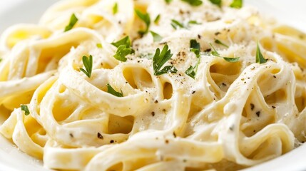 Creamy Alfredo fettuccine pasta topped with fresh herbs isolated